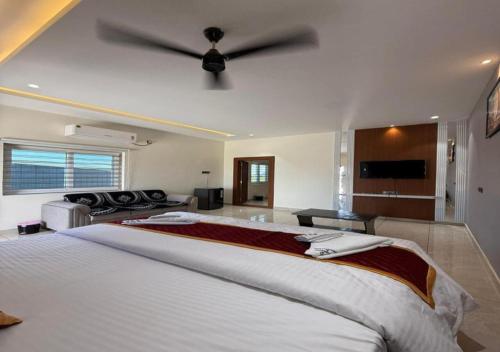 a bedroom with a large bed with a ceiling fan at SNR GRAND in Narasaraopet