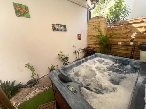 a jacuzzi tub in a backyard with plants at Le Cataleya - Résidence Terre et Truffes in Le Lamentin