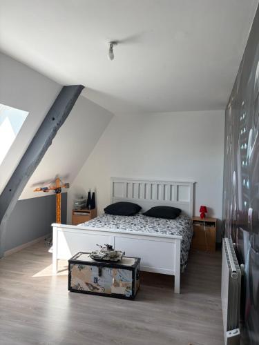 a bedroom with a white bed and a trunk at La forge in Auvers