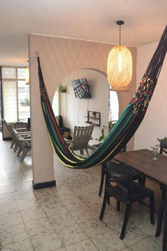 a hammock in a room with a dining room at Bau420! Backpackers HOSTAL in Cali