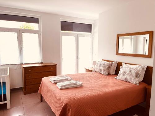 a bedroom with a bed with two towels on it at Casa de Casarelhos AL- T2 - AC - Terraço - BBQ - "Gerês" in Geres