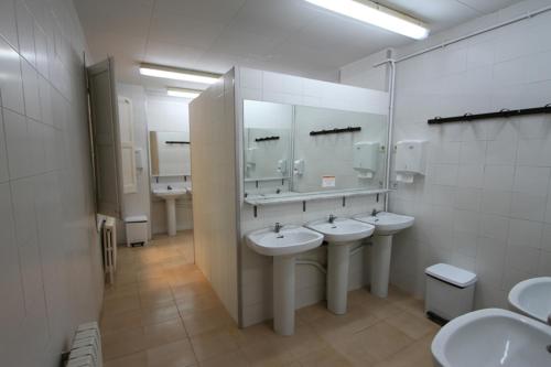 a bathroom with three sinks and three mirrors at Alberg Roques Blanques in Ribes de Freser