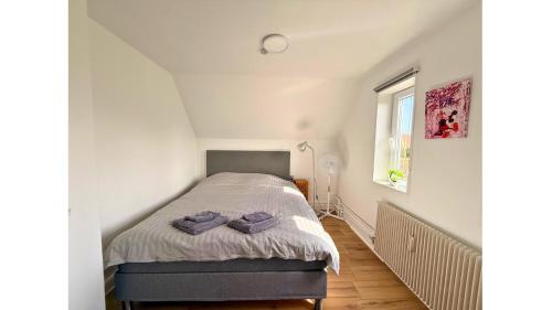 a bedroom with a bed with purple towels on it at Holeby Apartment 1 - next to Femern Puttgarden Lalandia Knuthenborg in Holeby
