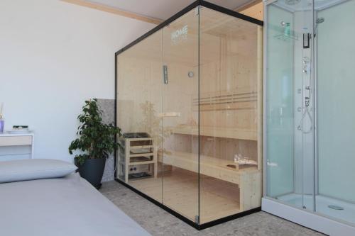 a shower with a glass door next to a bed at Villa Valdobbiadene Pool Spa in Valdobbiadene