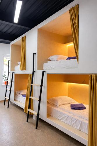 a room with three bunk beds in it at Skala Hostel in Almaty