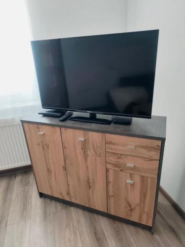 a flat screen tv sitting on top of a wooden entertainment center at Dom priamo pri rieke in Opatovce nad Nitrou