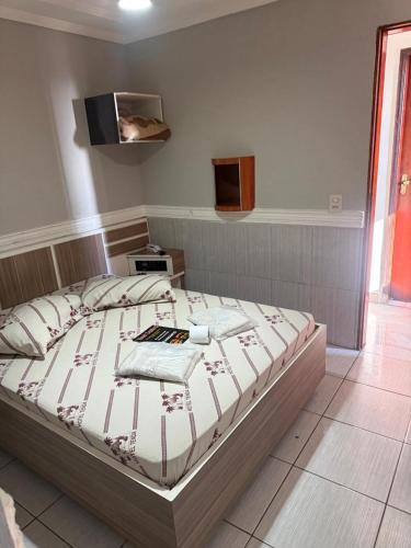 a bedroom with a bed with a tv on the wall at Hotel tenda 2 in Guarulhos