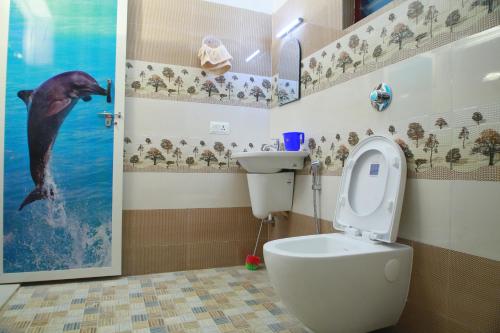 ein Bad mit einem WC und einem Delphin im Wasser in der Unterkunft Mount Spring Valley Homestay in Thekkady