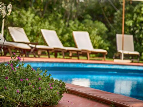 a group of chairs sitting next to a swimming pool at Hotel Villa Maremonti in Marina di Massa