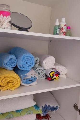 a shelf with towels and other towels in a bathroom at Habitación Ático Sol y Mar in Rincón de la Victoria