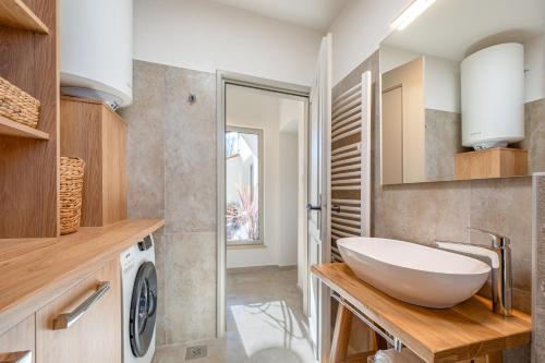 a bathroom with a sink and a washing machine at Villa Rocco in Kozljak