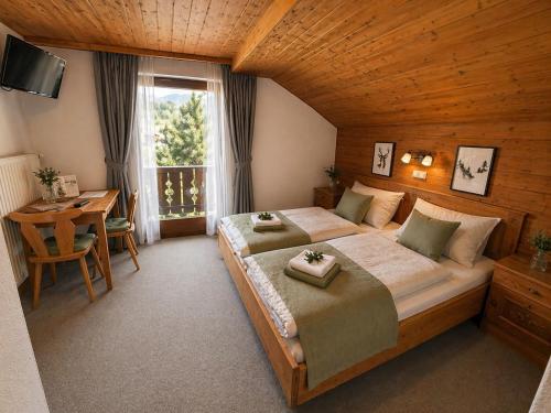 a bedroom with a bed and a table and a window at Pension Sonneck in Pfarrwerfen