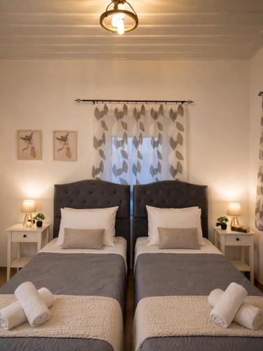 a bedroom with two beds and two lamps and a window at Evanthia's House in Arianá