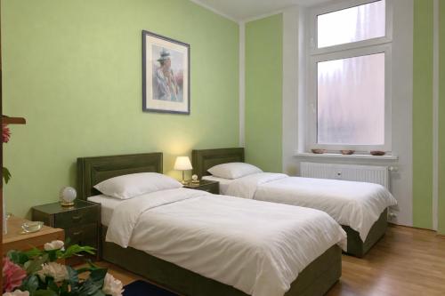 two beds in a room with green walls and a window at Gelsenkirchen Am Flöz in Gelsenkirchen
