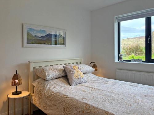 a bedroom with a bed and a window at Cottage 503 - Leenane in Leenaun