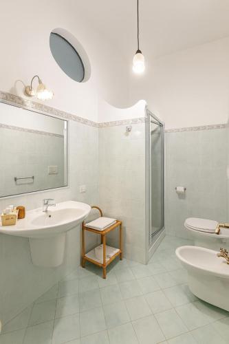 a white bathroom with a sink and a shower at Il Canneto in Positano