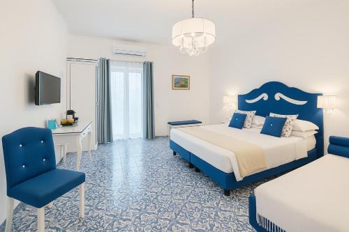 a bedroom with a bed and a desk and a chair at Il Canneto in Positano