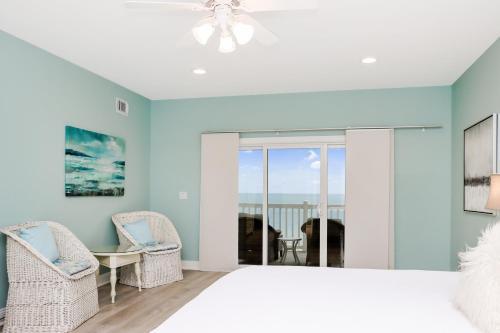 a bedroom with a bed and a table and chairs at Five on the Beach by Pristine Property Vacation Rentals in Cape San Blas