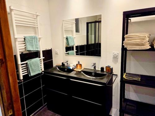 a bathroom with two sinks and a large mirror at Bohéme Chic in Saint-Dizier