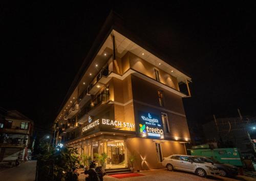 a building with a car parked in front of it at night at Treebo Calangute Beach Stay in Calangute