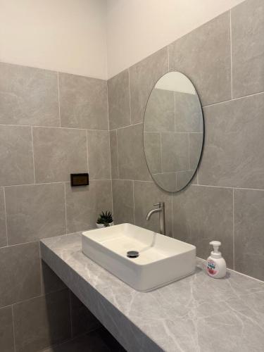 a bathroom with a white sink and a mirror at Tiny Home - Hin Lad Waterfall in Nathon Bay