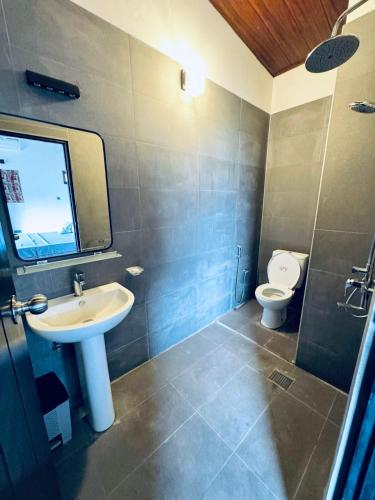 a bathroom with a sink and a toilet at ARHH castle in Ginigathena