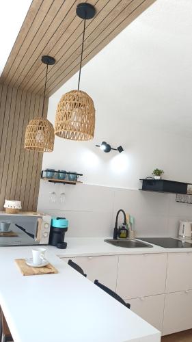 a kitchen with two pendant lights over a counter at Seabird Lisbon Studio in Charneca