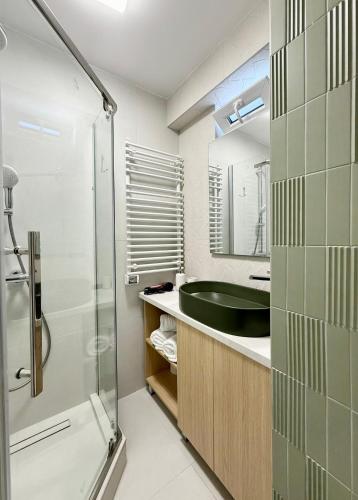 a bathroom with a glass shower and a sink at Central View Apartment in Timişoara
