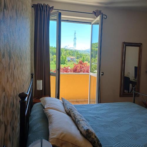 a bedroom with a bed and a large window at ACERO ROSSO in Pianfei