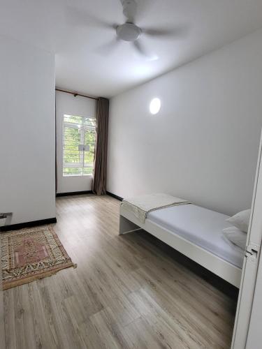 a white room with a bed and a window at Puteri Elaisha Homestay in Batu Arang