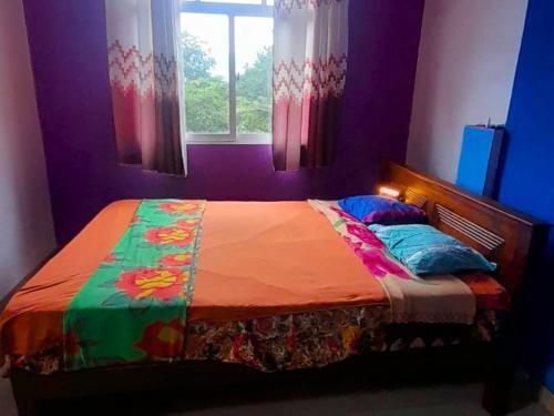 a bedroom with a colorful bed with a window at Ice mango homestay Badulla in Badulla