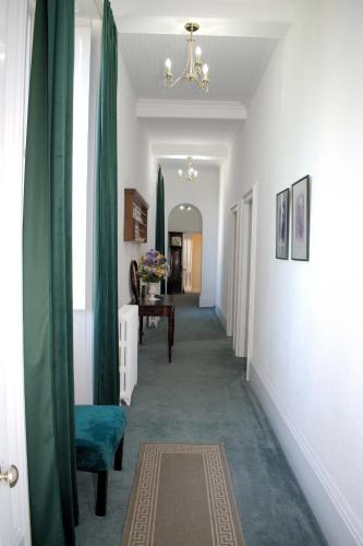 a hallway with green curtains and a hallway with a table at Collins House in Knaresborough