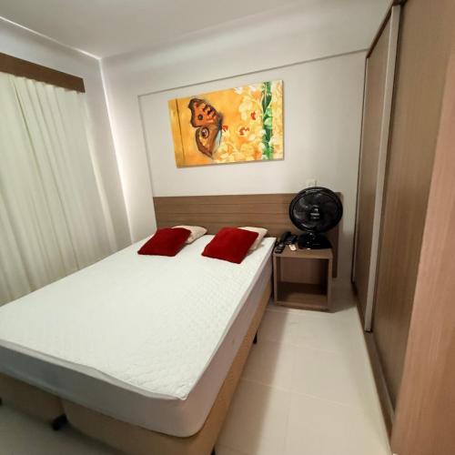a bedroom with a bed with two red pillows at Veredas Do Rio Quente Flat Service 723 in Rio Quente