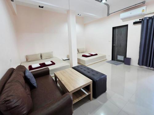 a living room with a couch and a table at Lynn Living (ลินน์ ลิฟวิ่ง) in Ban Non Muang