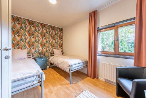 a bedroom with two beds and a window at Le charron in Bièvre