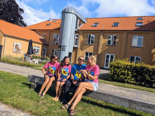 a group of people sitting on a bench at Nexø Modern Hostel. Private Rooms in Neksø