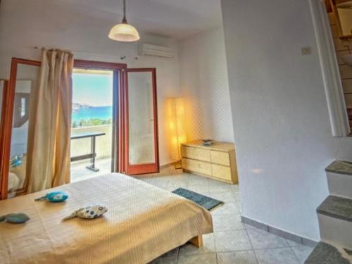 a bedroom with a bed and a view of the ocean at Villa Vassia in Koundouros