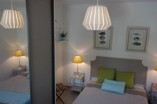 a bedroom with two beds and two lamps and a mirror at Grau du Roi Le Sémaphore in Le Grau-du-Roi