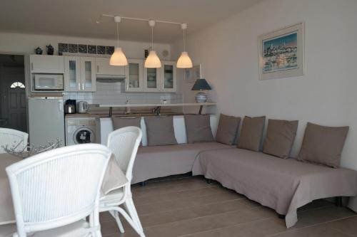 un salon avec un canapé et des chaises et une cuisine dans l'établissement Grau du Roi Le Sémaphore, au Grau-du-Roi
