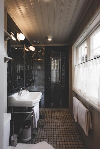 a bathroom with a sink and a shower at Badhotellet Villa Berg in Norrtälje