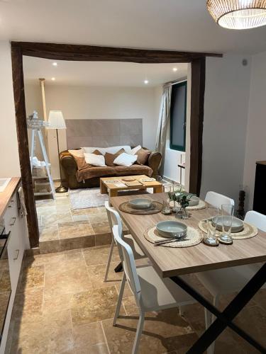 a living room with a table and a couch at Le domaine des amours in Saint-Josse