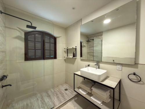 a bathroom with a sink and a shower and a mirror at Hueso cue 105 in Paso de la Patria