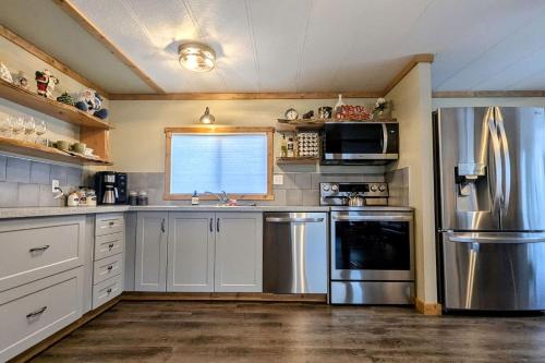 a kitchen with white cabinets and a stainless steel refrigerator at Hillcrest Hideaway Spacious Mountain View Oasis in Hillcrest Mines