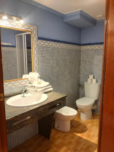 a bathroom with a sink and a toilet at Unique Apartahotel 4-3 in Torrevieja