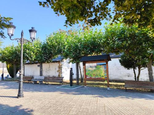 a park with two benches and a street light at Casa Rural Picón con jardín y piscina privada in Ocero