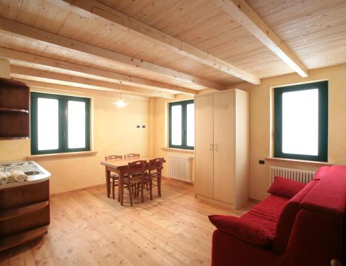 a living room with a table and a red couch at Normena Mountain Residence in Tizzano Val Parma