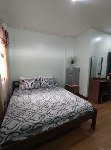 a bedroom with a bed and a mirror at GLJ Apartment in Ormoc