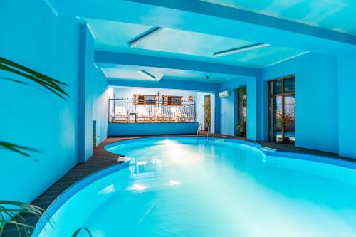 a swimming pool in a house with blue lighting at Chateau Montagne Hotel Troyan in Troyan