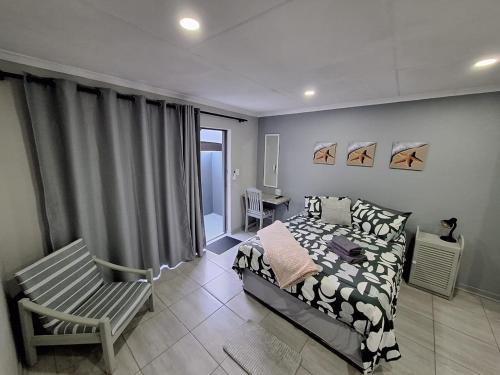 a bedroom with a bed and a chair at Ivy Roots Guest House in Mokopane