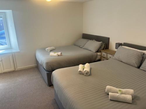 a room with two beds with towels on them at Lower Mill Apartment in Newmilns